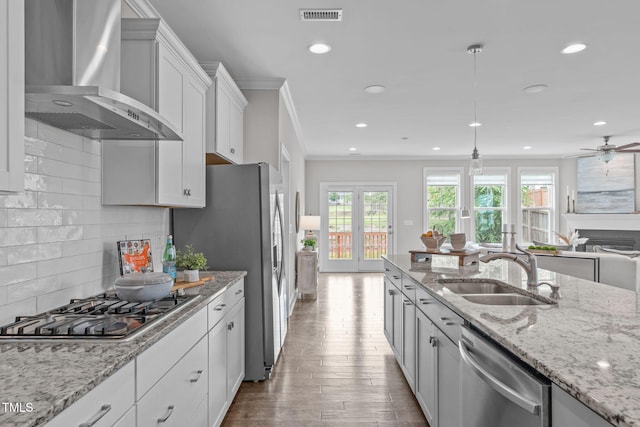 1017 Blackpool Ct, Apex, NC 27502 - kitchen with wall chimney exhaust hood, stainless steel appliances, recessed lighting, crown molding, and decorative backsplash