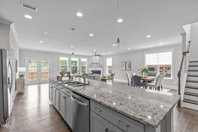 1017 Blackpool Ct, Apex, NC 27502 - kitchen with stainless steel appliances, ornamental molding, an island with sink, recessed lighting, and gray cabinets