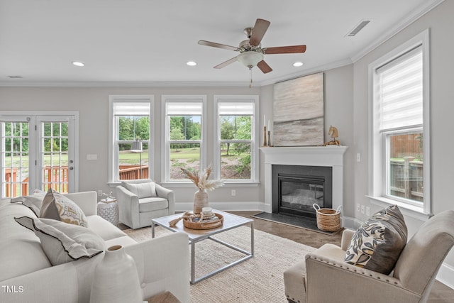 1017 Blackpool Ct, Apex, NC 27502 - living area with plenty of natural light, a fireplace with flush hearth, a ceiling fan, ornamental molding, and wood finished floors