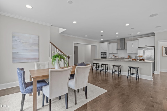 1017 Blackpool Ct, Apex, NC 27502 - dining space featuring ornamental molding, dark wood finished floors, recessed lighting, and stairs