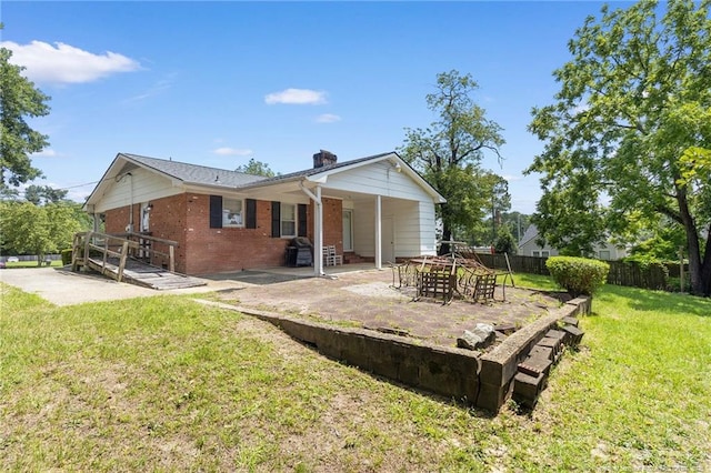 1319 Levy Dr, Fayetteville, NC 28305 - rear view of house with brick siding, a patio, and a chimney