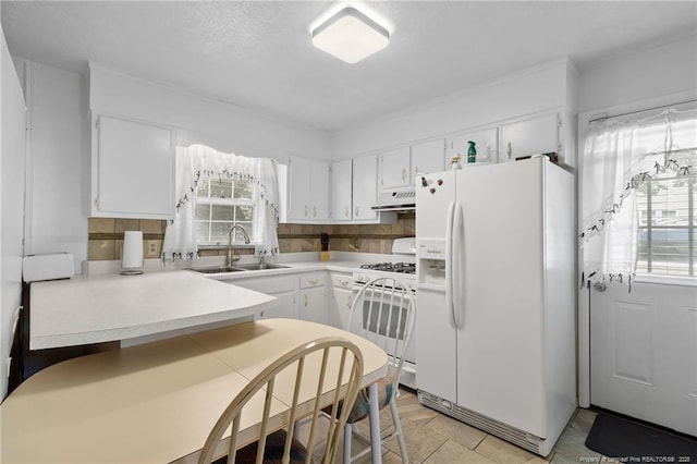 1319 Levy Dr, Fayetteville, NC 28305 - kitchen with white appliances, under cabinet range hood, a peninsula, and white cabinetry