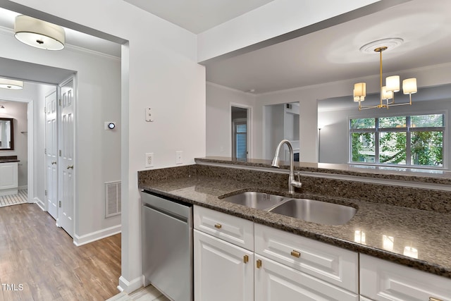 1210 Westview Ln Unit 203, Raleigh, NC 27605 - kitchen with stainless steel dishwasher, dark stone counters, ornamental molding, white cabinetry, and light wood-style flooring