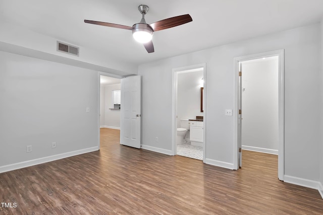 1210 Westview Ln Unit 203, Raleigh, NC 27605 - unfurnished bedroom featuring a walk in closet, wood finished floors, ensuite bath, and ceiling fan