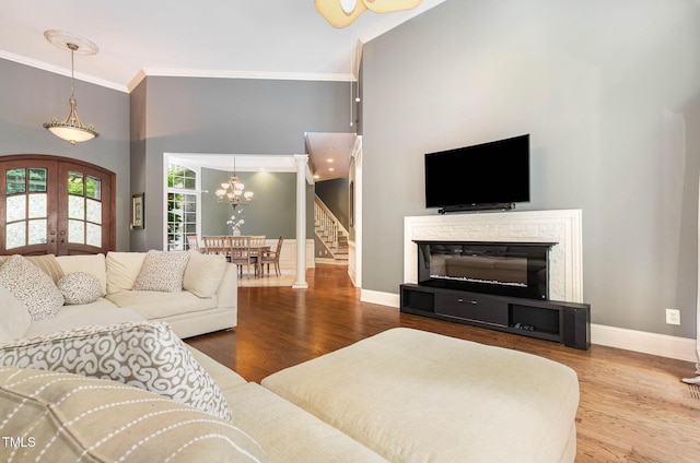 3712 Highland Creek Dr, Apex, NC 27539 - living room with ornamental molding, stairway, a towering ceiling, a chandelier, and wood finished floors