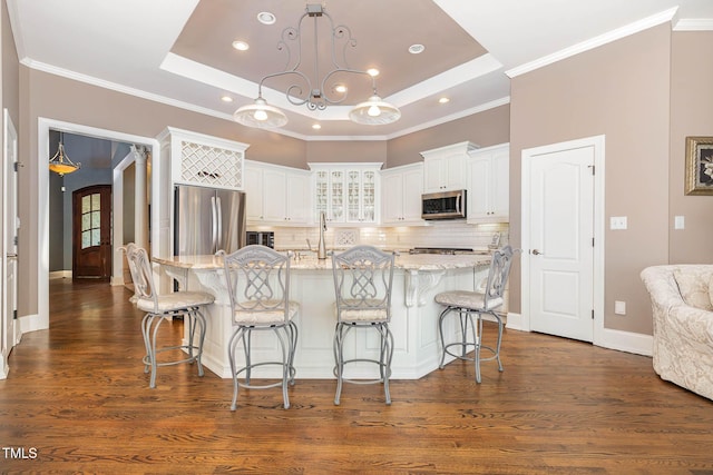 3712 Highland Creek Dr, Apex, NC 27539 - kitchen featuring appliances with stainless steel finishes, a raised ceiling, white cabinetry, glass insert cabinets, and recessed lighting