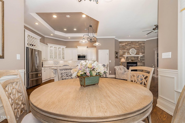 3712 Highland Creek Dr, Apex, NC 27539 - dining room with a ceiling fan, recessed lighting, a fireplace, dark wood-style flooring, and crown molding