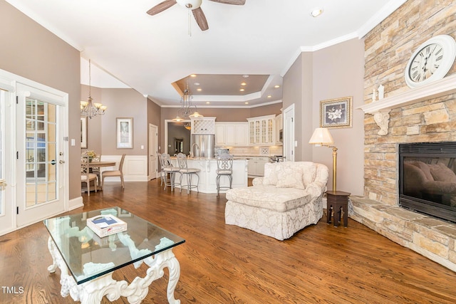 3712 Highland Creek Dr, Apex, NC 27539 - living room featuring crown molding, a stone fireplace, dark wood-type flooring, ceiling fan, and a chandelier