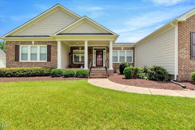 1421 Hopson Downs Ct, Holly Springs, NC 27540 - view of front of home with brick siding, a front lawn, and covered porch