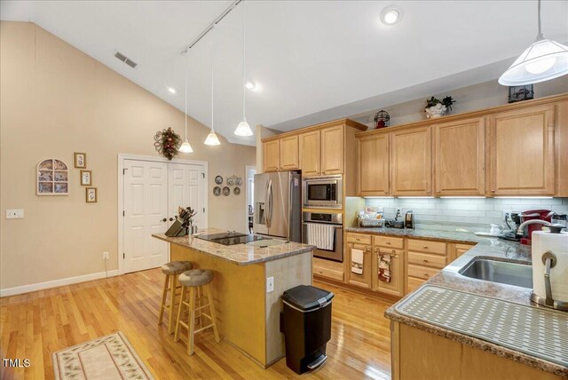 1421 Hopson Downs Ct, Holly Springs, NC 27540 - kitchen featuring stainless steel appliances, light wood-type flooring, backsplash, a center island, and high vaulted ceiling