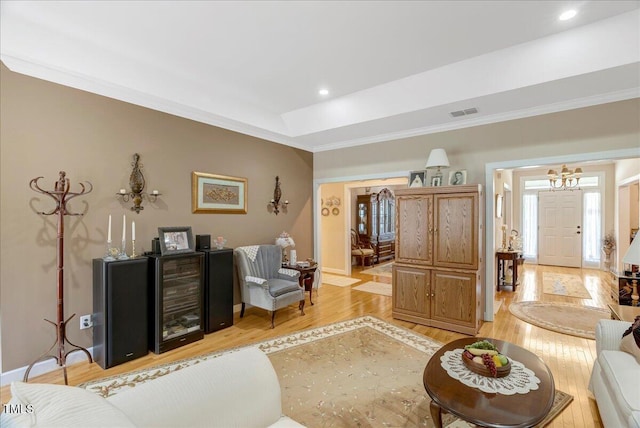 1421 Hopson Downs Ct, Holly Springs, NC 27540 - living area with beverage cooler, light wood finished floors, crown molding, a chandelier, and recessed lighting