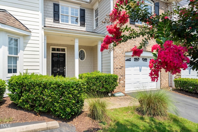 5515 S Roxboro St Unit 3, Durham, NC 27713 - entrance to property featuring brick siding, a garage, driveway, and covered porch