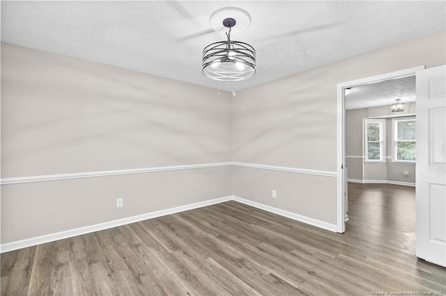 806 Eagle Landing Dr, Hope Mills, NC 28348 - spare room with a chandelier, wood finished floors, and a textured ceiling