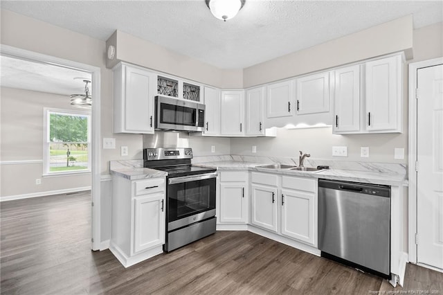 806 Eagle Landing Dr, Hope Mills, NC 28348 - kitchen featuring appliances with stainless steel finishes, dark wood-style floors, a textured ceiling, white cabinets, and light stone counters