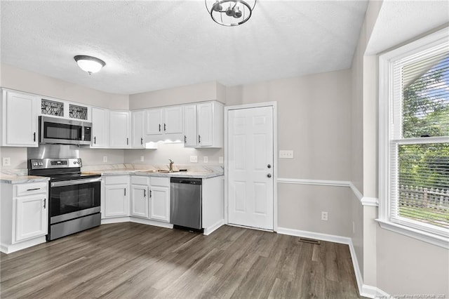 806 Eagle Landing Dr, Hope Mills, NC 28348 - kitchen featuring stainless steel appliances, dark wood-style floors, plenty of natural light, white cabinets, and a textured ceiling