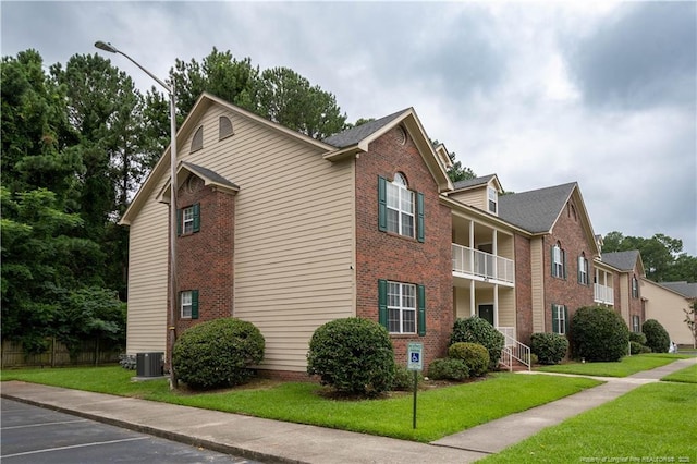 3401 Lainey Ln Unit D, Fayetteville, NC 28314 - view of side of home with brick siding, a balcony, a yard, and uncovered parking