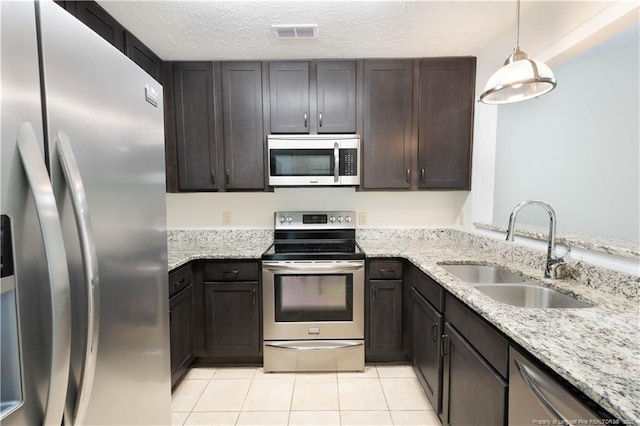 3401 Lainey Ln Unit D, Fayetteville, NC 28314 - kitchen featuring appliances with stainless steel finishes, light tile patterned flooring, light stone counters, dark brown cabinets, and pendant lighting