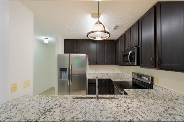 3401 Lainey Ln Unit D, Fayetteville, NC 28314 - kitchen featuring stainless steel appliances, light stone counters, dark brown cabinets, a peninsula, and a textured ceiling