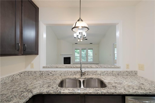 3401 Lainey Ln Unit D, Fayetteville, NC 28314 - kitchen with dark brown cabinetry, a chandelier, light stone counters, and pendant lighting