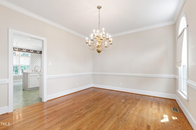 2464 Village Of Wakefield Dr, Zebulon, NC 27597 - unfurnished room featuring a chandelier, light wood-style floors, healthy amount of natural light, and ornamental molding