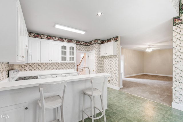 2464 Village Of Wakefield Dr, Zebulon, NC 27597 - kitchen with stove, a peninsula, a breakfast bar, and white cabinetry