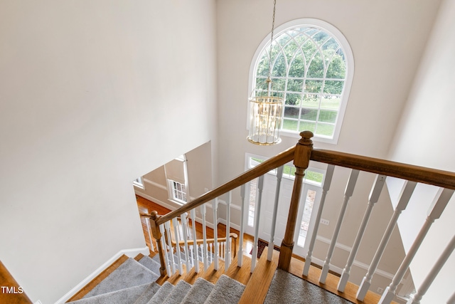 2464 Village Of Wakefield Dr, Zebulon, NC 27597 - stairs featuring wood finished floors, a chandelier, and a towering ceiling