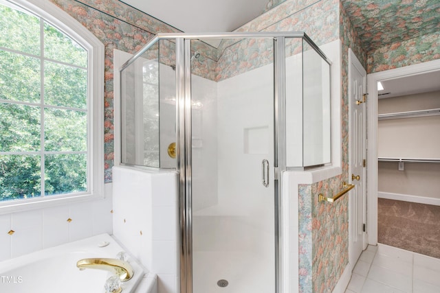 2464 Village Of Wakefield Dr, Zebulon, NC 27597 - bathroom featuring a shower stall, a walk in closet, tile patterned floors, wallpapered walls, and a garden tub