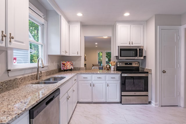 104 Silver Fox Ct, Cary, NC 27511 - kitchen featuring stainless steel appliances, light marble finish floors, recessed lighting, white cabinetry, and light stone counters