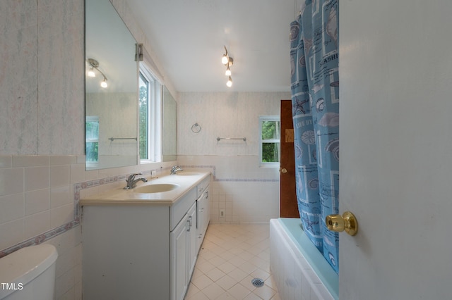 1310 Martin Luther King Pkwy, Durham, NC 27707 - bathroom featuring tile walls, tile patterned flooring, double vanity, tiled shower / bath, and wainscoting