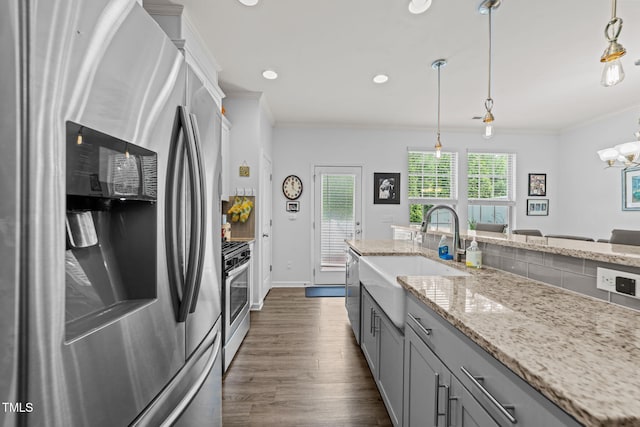 3801 Windsnap Dr, Wake Forest, NC 27587 - kitchen featuring appliances with stainless steel finishes, crown molding, gray cabinetry, dark wood finished floors, and light stone countertops