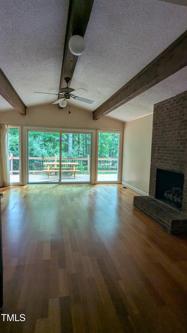 11636 Appaloosa Run W, Raleigh, NC 27613 - unfurnished living room featuring a textured ceiling, ceiling fan, wood finished floors, beam ceiling, and a fireplace