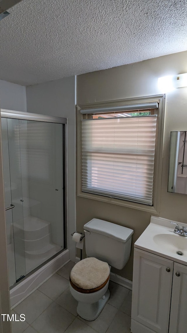 11636 Appaloosa Run W, Raleigh, NC 27613 - bathroom with a textured ceiling, a stall shower, vanity, tile patterned floors, and plenty of natural light