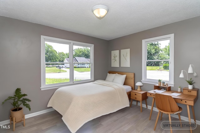 204 Mercer Ct, Goldsboro, NC 27530 - bedroom with wood finished floors, multiple windows, and a textured ceiling
