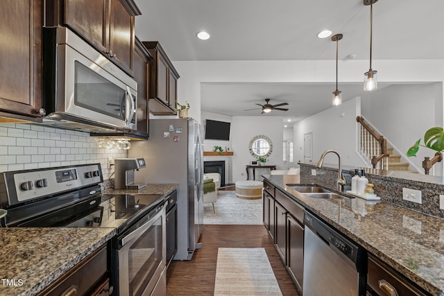2700 Benevolence Dr, Raleigh, NC 27610 - kitchen with appliances with stainless steel finishes, dark wood-style flooring, a ceiling fan, dark brown cabinetry, and backsplash