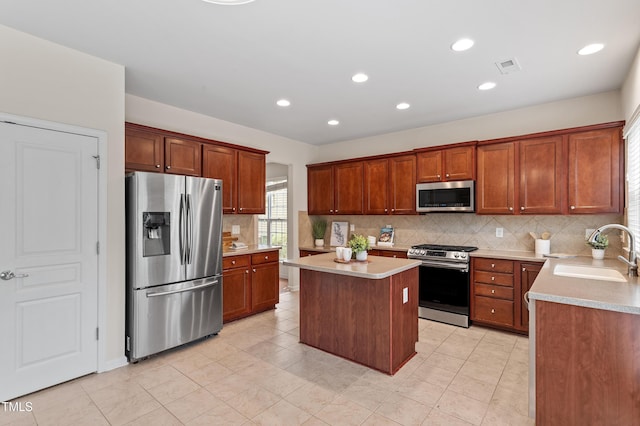 212 Oswego Ct, Morrisville, NC 27560 - kitchen featuring appliances with stainless steel finishes, backsplash, a kitchen island, light countertops, and recessed lighting