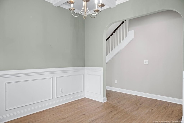45 Commodore Ct, Cameron, NC 28326 - unfurnished room featuring arched walkways, wood finished floors, a chandelier, stairs, and wainscoting