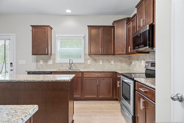 45 Commodore Ct, Cameron, NC 28326 - kitchen featuring appliances with stainless steel finishes, light stone counters, light wood finished floors, healthy amount of natural light, and recessed lighting