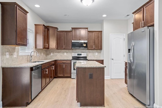 45 Commodore Ct, Cameron, NC 28326 - kitchen featuring stainless steel appliances, a kitchen island, light wood-type flooring, light stone counters, and recessed lighting