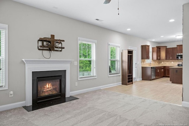 45 Commodore Ct, Cameron, NC 28326 - unfurnished living room featuring light colored carpet, a fireplace with flush hearth, a ceiling fan, and recessed lighting