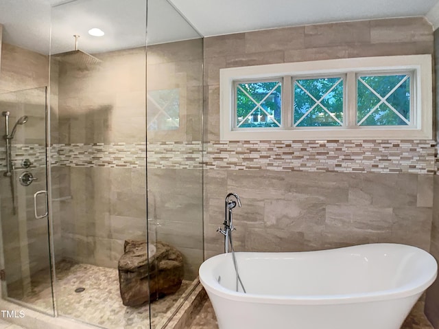3575 Bragg Valley Ln, Wake Forest, NC 27587 - bathroom with a stall shower, a soaking tub, and tile walls