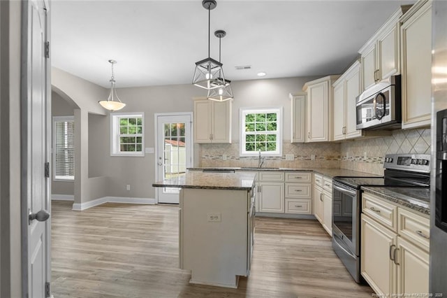 4041 Lifestyle Rd, Fayetteville, NC 28312 - kitchen featuring appliances with stainless steel finishes, arched walkways, light wood-style floors, backsplash, and recessed lighting