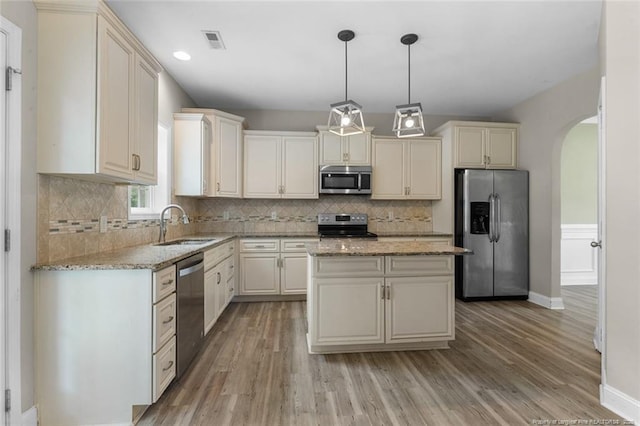 4041 Lifestyle Rd, Fayetteville, NC 28312 - kitchen with appliances with stainless steel finishes, arched walkways, light wood-type flooring, light stone counters, and recessed lighting