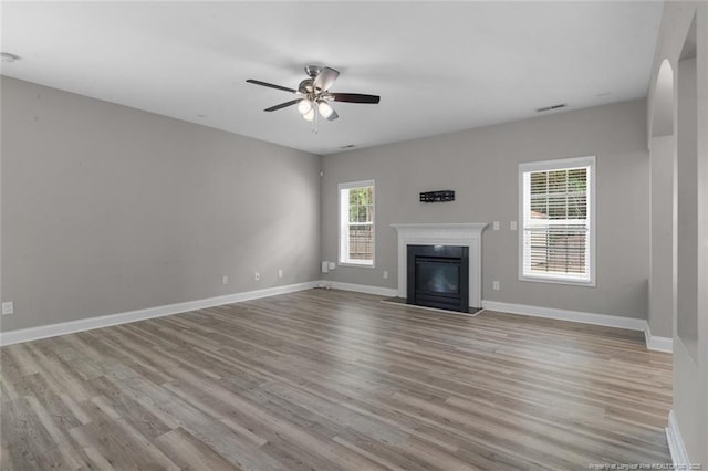 4041 Lifestyle Rd, Fayetteville, NC 28312 - unfurnished living room featuring ceiling fan, wood finished floors, and a glass covered fireplace