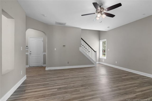4041 Lifestyle Rd, Fayetteville, NC 28312 - unfurnished room featuring arched walkways, a ceiling fan, stairs, and wood finished floors