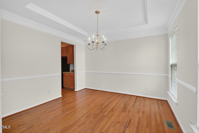 4518 Coral Dr, Durham, NC 27713 - empty room featuring a chandelier, light wood-style floors, crown molding, and a raised ceiling