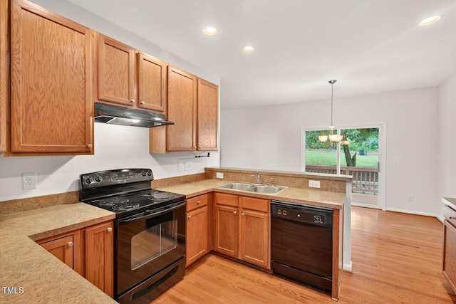 4518 Coral Dr, Durham, NC 27713 - kitchen featuring black appliances, under cabinet range hood, a peninsula, light wood-type flooring, and light countertops