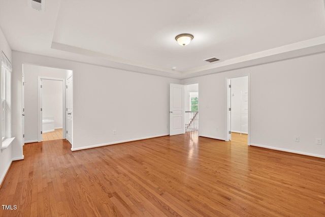 4518 Coral Dr, Durham, NC 27713 - empty room with a tray ceiling and light wood-style flooring