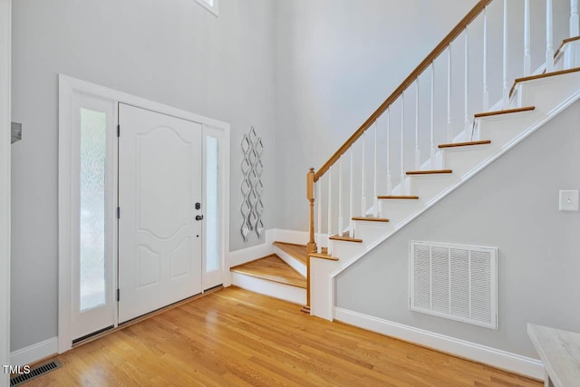 7269 Bedford Ridge Dr, Apex, NC 27539 - entryway with wood finished floors, stairway, and a towering ceiling