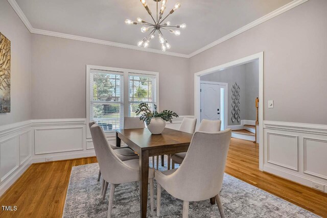 7269 Bedford Ridge Dr, Apex, NC 27539 - dining room featuring a chandelier, ornamental molding, light wood-type flooring, and wainscoting