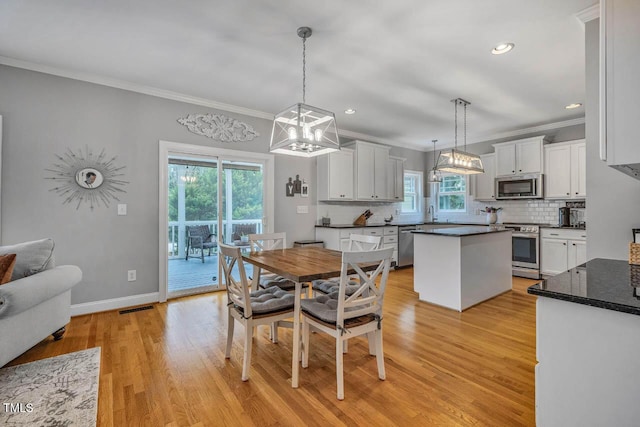 7269 Bedford Ridge Dr, Apex, NC 27539 - dining area featuring ornamental molding, light wood-type flooring, recessed lighting, and a chandelier